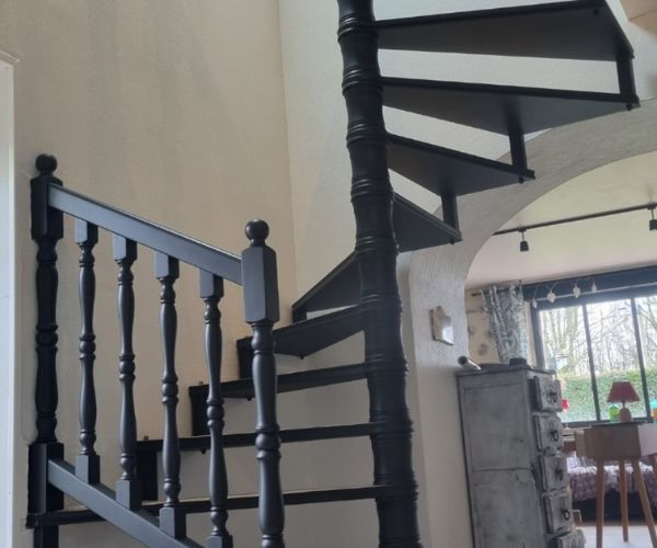Escalier colimaçon peint en noir mat après rénovation intérieure.