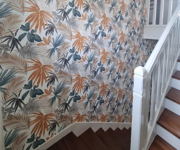 Pose d’un papier peint tropical dans une cage d’escalier par Ouest Déco.