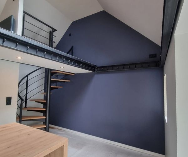 Mur peint en bleu anthracite dans une pièce avec mezzanine à Brest.
