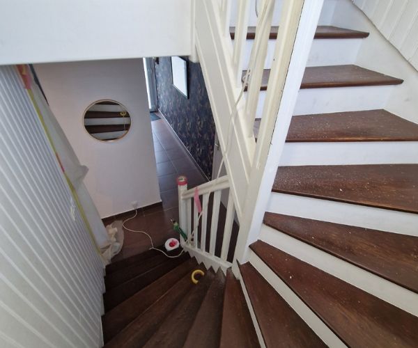 Escalier en bois rénové avec marches vitrifiées et contremarches blanches à Brest.