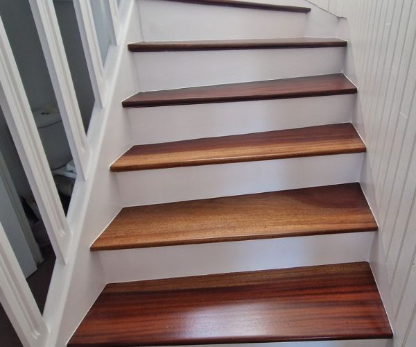 Escalier en bois rénové avec peinture blanche et marches vitrifiées à Brest.